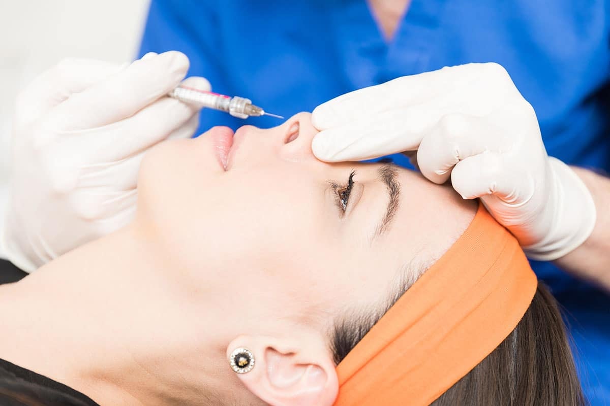 Woman receiving liquid rhinoplasty injection