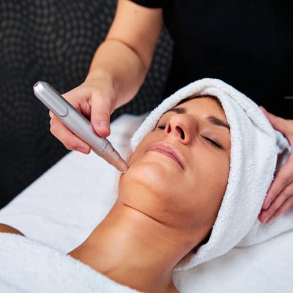 A woman receiving microneedling treatment