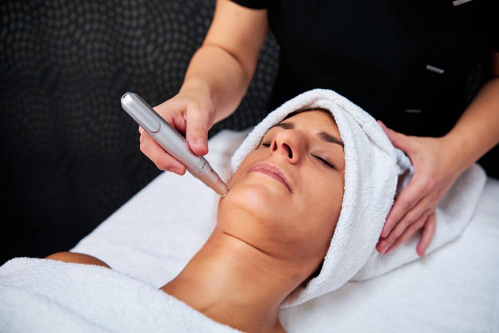 A woman receiving microneedling treatment